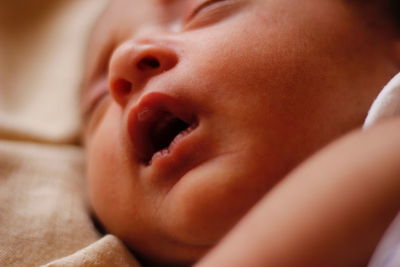 Close-up of cute baby girl sleeping at home