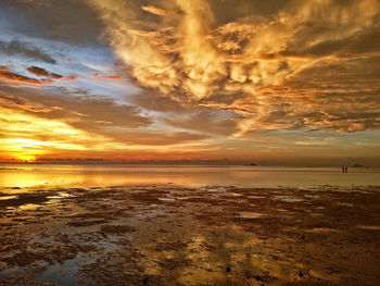 Scenic view of beach against dramatic sky