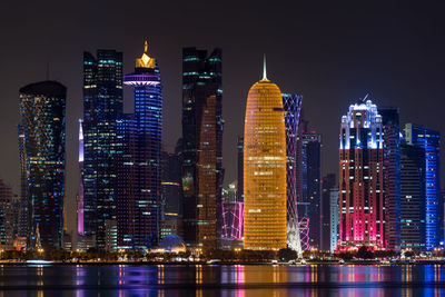 Illuminated buildings against sky at night