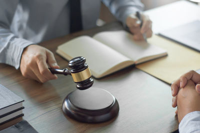 Midsection of man holding book on table