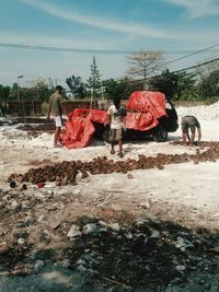 People walking on land against sky