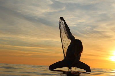 Silhouette horse on beach against sky during sunset