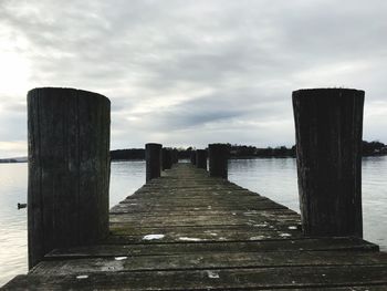 Wooden pier over sea against sky