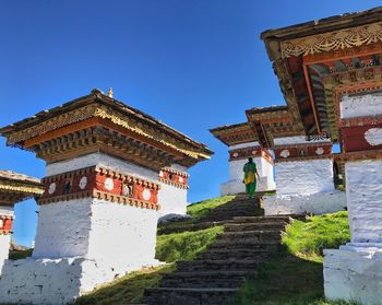 Wide view of women climbing the stair of a large temple, monastry against sky