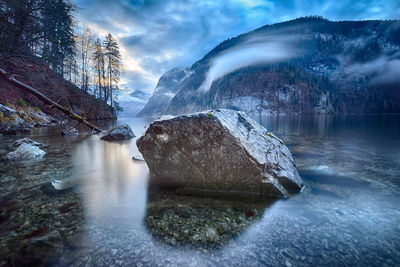 Rock amidst lake against mountain