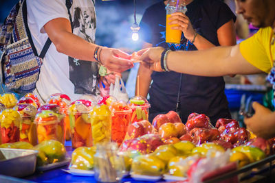 Midsection of people at market stall