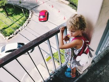 High angle view of girl standing by railing