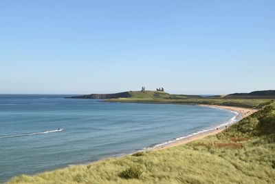 Calm blue sea against clear sky