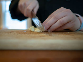 Midsection of person preparing food on cutting board