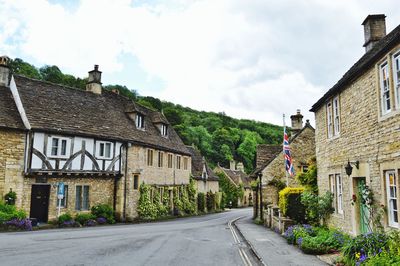 Street amidst houses and buildings against sky