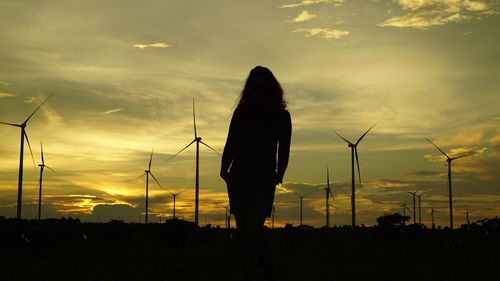Low angle view of silhouette woman standing on field against sky