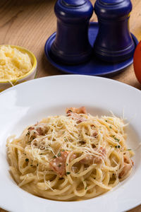 High angle view of spaghetti with carbonara in plate on table