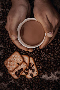 High angle view of hand holding coffee cup