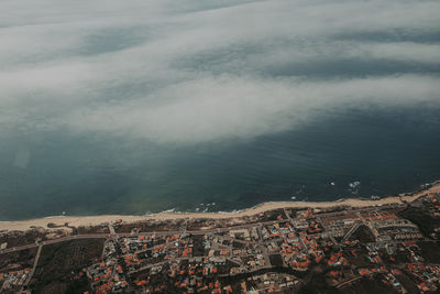 High angle view of townscape by sea against sky