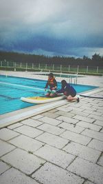 Pier on sea against cloudy sky