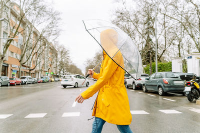 Rear view of woman holding umbrella