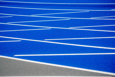 Clean new outdoor blue running track with white lines and copy space.