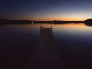 Pier on lake at sunset