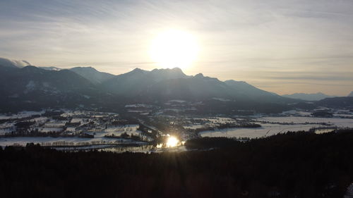 Scenic view of lake and mountains against sky during sunset