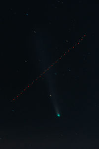 Low angle view of illuminated lights against sky at night with the comet neowise
