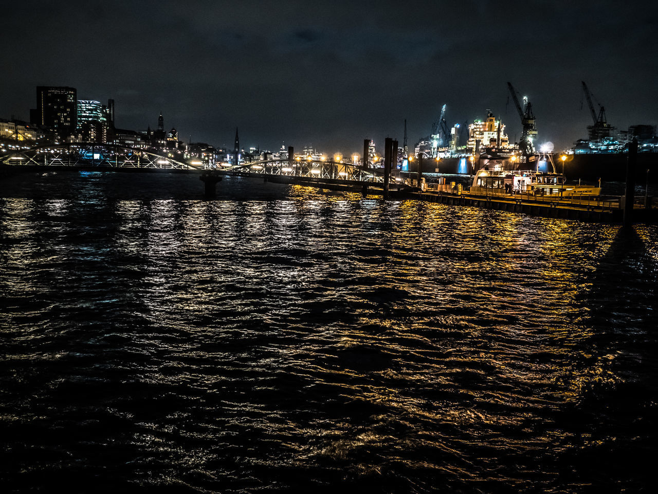 ILLUMINATED CITY AT WATERFRONT