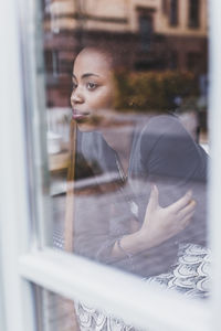 Young woman in a cafe looking out of window