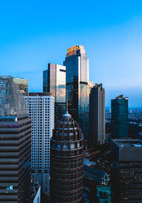 Modern buildings in city against clear blue sky