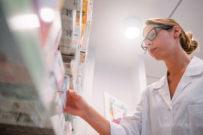 Side view of young woman working in laboratory