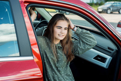 Portrait of smiling young woman in car