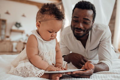 Father and daughter looking at digital tablet at home