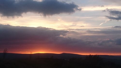 Scenic view of silhouette mountains against dramatic sky