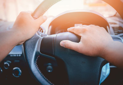 Midsection of woman holding smart phone in car