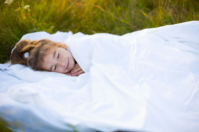 Portrait of young woman lying on bed