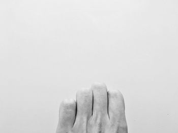 Cropped hand of person against gray background