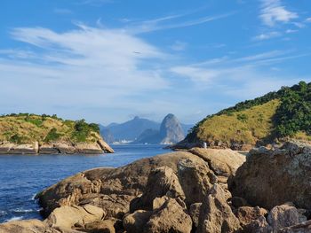 Scenic view of sea and mountains against sky