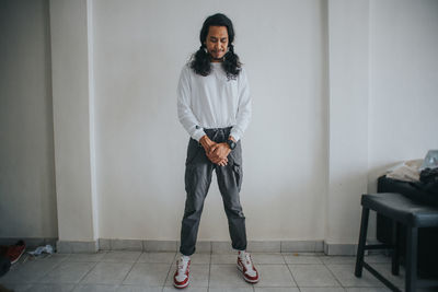 Portrait of young man standing at home