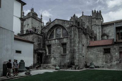 People in front of historic building against sky