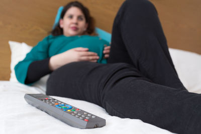 Rear view of women sitting on bed at home