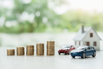 Close-up of toy cars and coins on table