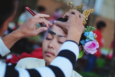 Beautician applying make-up on young woman