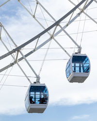 Low angle view of overhead cable car against sky