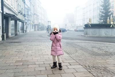 Full length of woman standing on street in city