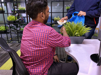 Rear view of man and woman sitting on table