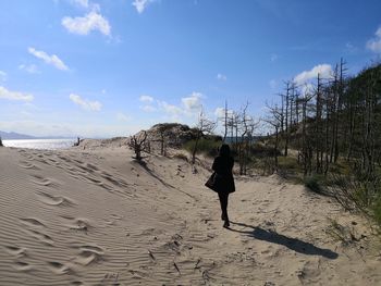 Rear view of man walking on beach