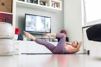 Side view of woman exercising in gym