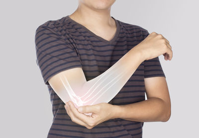 Midsection of woman holding paper against white background