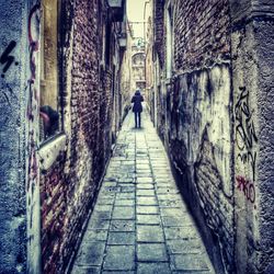Rear view of woman walking on alley
