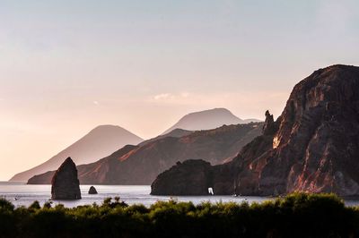 Scenic view of sea and mountains against sky