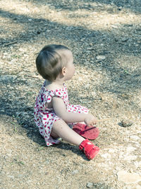 High angle view of baby girl sitting on field