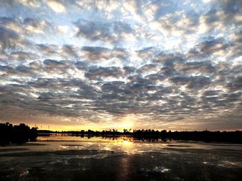 Scenic view of river against sky at sunset